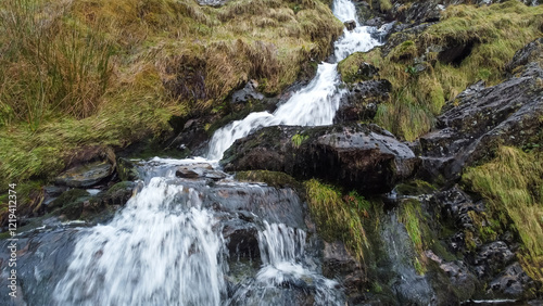 Aerial view of small waterfall cascading down Moel Druman mountain in Moelwyn mountains