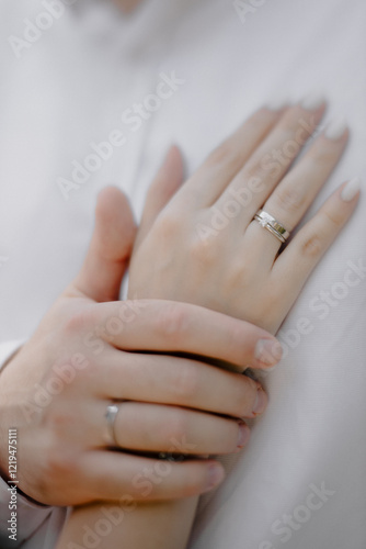 hands of the groom and bride on white 
