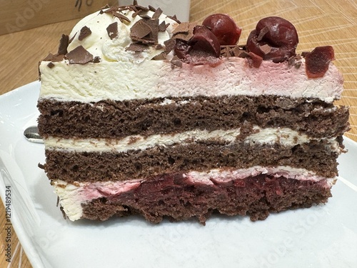 Decadent black forest cake slice with whipped cream and cherries photo