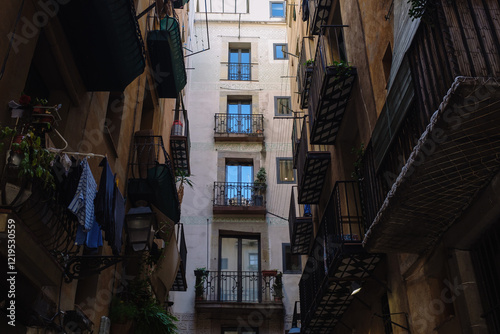 Clothes hanging from a balcony in a narrow alley in barcelona, spain photo