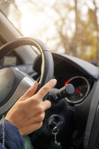 Lady hand holding steering wheel of car while driving.