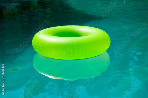 Swimming bright ring. Fun in pool. Inflatable ring at poolside. Summer vacation. Relaxing at pool. Summer resort vacation. Recreation concept. Inflatable ring in swimming pool. Sunlit pool afternoons
