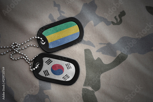 vintage army blank, dog tag with flag of gabon and south korea on the khaki texture background. military concept.