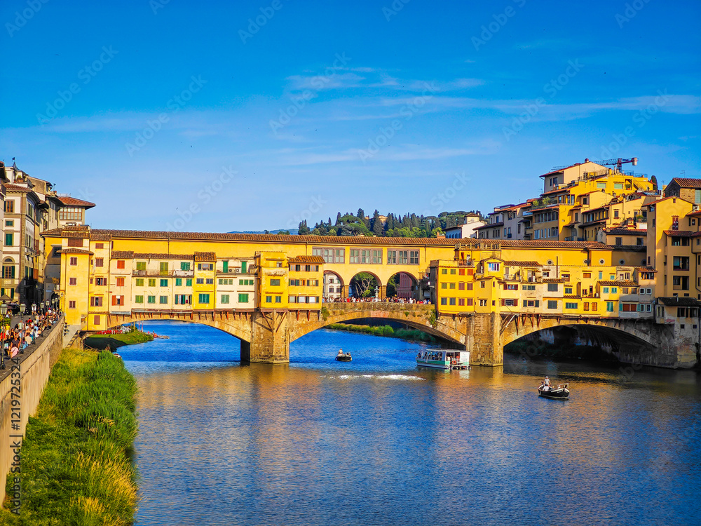Obraz premium Ponte Vecchio bridge over Arno River in Florence. Picturesque medieval arched river bridge with Roman origins, lined with jewelry and souvenir shops.