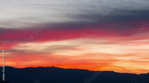 4K footage capturing a colorful sunset over the mountains in Death Valley National Park, California. The vibrant red and blue hues in the sky contrast with the rugged desert landscape below.