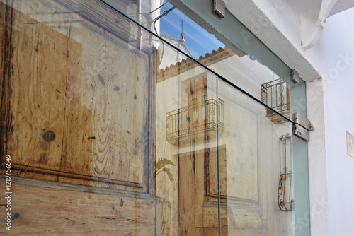 Fototapeta Naklejka Na Ścianę i Meble -  Glass door with reflections of Altea old town buildings. Small picturesque Altea town with narrow streets and whitewashed houses near Mediterranean sea, Alicante province, Valencian Community, Spain