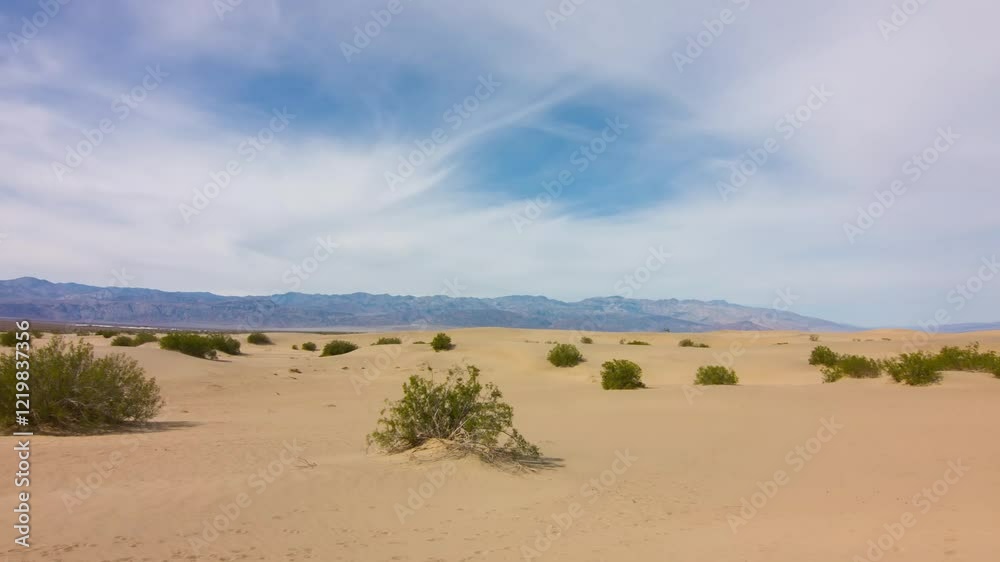 Experience an aerial panoramic view of golden sand dunes contrasting with mountains in the wild outdoors of Death Valley National Park, a breathtaking sight on a clear sunny day. Experience an aerial panoramic view of golden sand dunes contrasting with mountains in the wild outdoors of Death Valley National Park, a breathtaking sight on a clear sunny day.