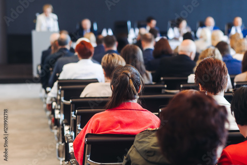 Audience at the modern conference hall listens to panel discussion, people on a congress event together listen to speaker on stage at convention, business seminar, large venue for forum presentation