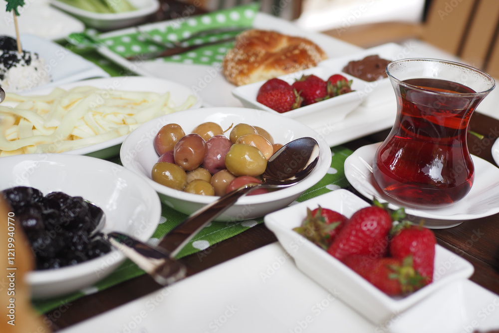 Traditional Breakfast Table Featuring Tea, Fresh Fruits, Olives, and Pastries Traditional Breakfast Table Featuring Tea, Fresh Fruits, Olives, and Pastries