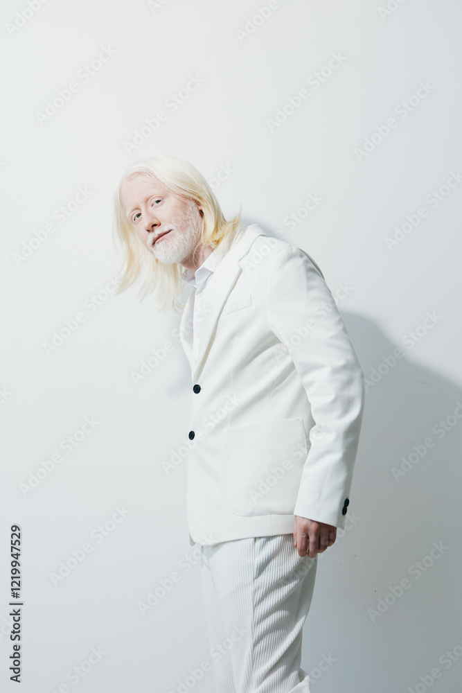Portrait of a stylish elderly man with long white hair dressed in a crisp white suit against a plain white background, embodying elegance, confidence, and uniqueness in fashion Portrait of a stylish elderly man with long white hair dressed in a crisp white suit against a plain white background, embodying elegance, confidence, and uniqueness in fashion