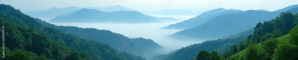 Fototapeta premium Misty valleys with towering peaks shrouded in fog, azure, greenery, foliage
