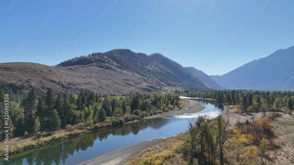 RIVER IN A VALLEY WITH MOUNTAINS AND BLUE SKY RIVER IN A VALLEY WITH MOUNTAINS AND BLUE SKY