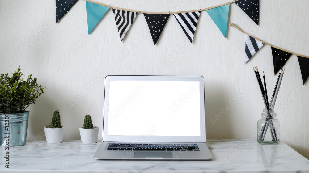 Fototapeta premium Laptop mockup for website presentation. There is an open laptop with a white screen on the table, and festival flags hang on the wall behind it. There are cacti, a green potted plant, and pencils