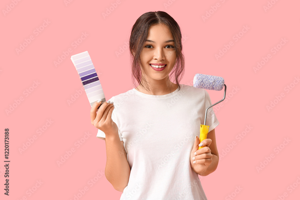 Beautiful young woman with paint roller and palette samples on pink background Beautiful young woman with paint roller and palette samples on pink background