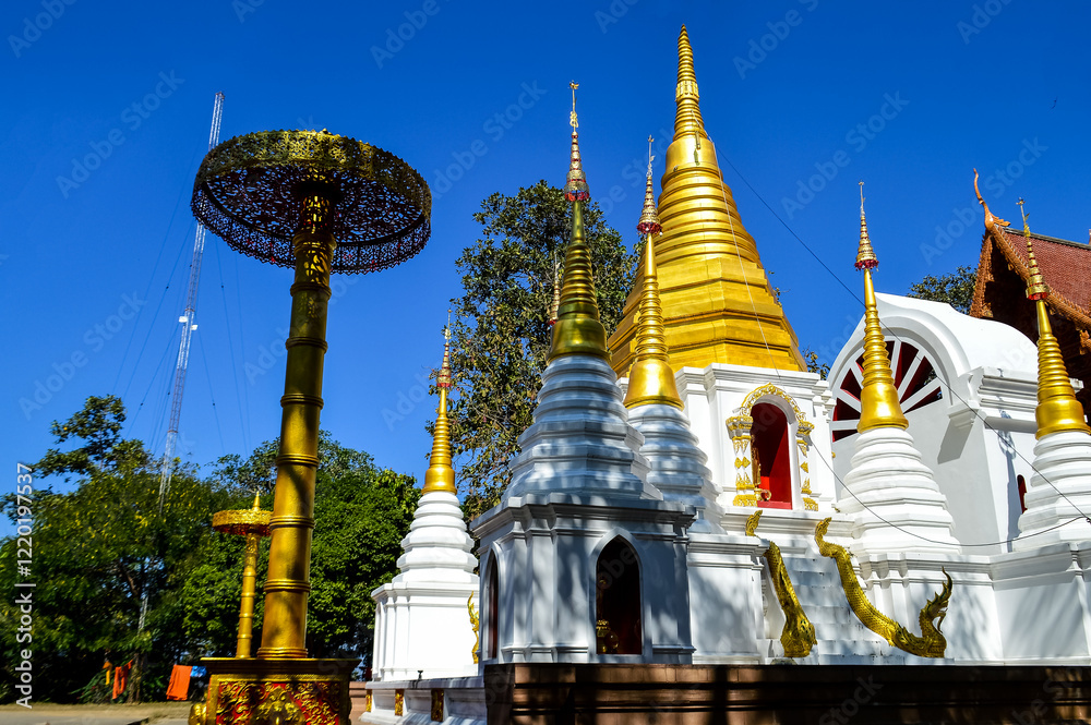 Fototapeta premium Chapel and Golden Pagoda, Lanna Architecture, Symbols of Buddhism, South East Asia at Doi Sapphanyu Temple, Mae Wang Chiangmai, Northern Thailand