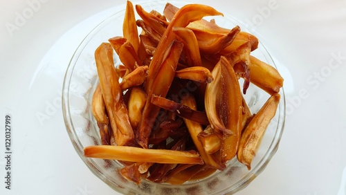 Crispy jackfruit or chakka chips deep oil fried kerala south indian snack inside bowl isolated on white table background. Closeup macro top view. Delicious unhealthy junk food. photo