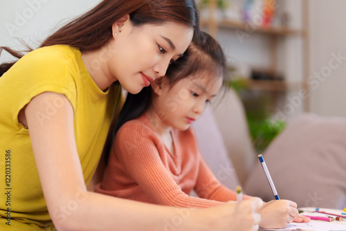 A mother assisting her daughter with homework at the table, surrounded by books and stationery, fostering learning and support.