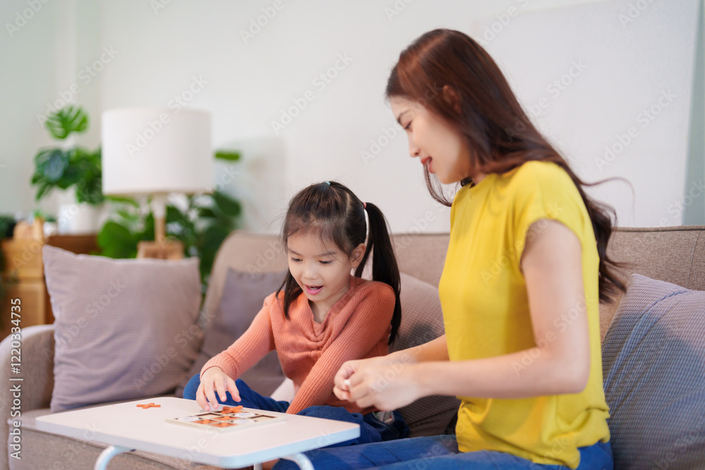 A mother and daughter enjoying a playful game of tic-tac-toe together on a table, sharing laughter and connection. A mother and daughter enjoying a playful game of tic-tac-toe together on a table, sharing laughter and connection.