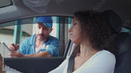 A mechanic is providing service to a customer who has come into a car service center.
