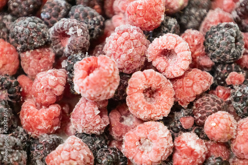 Healthy berry mix of frozen raspberries and blackberries. Frozen berries against background.