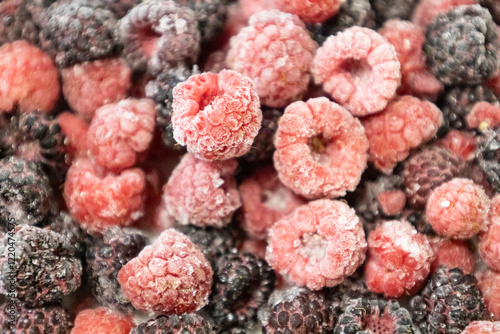 Healthy berry mix of frozen raspberries and blackberries. Frozen berries against background.