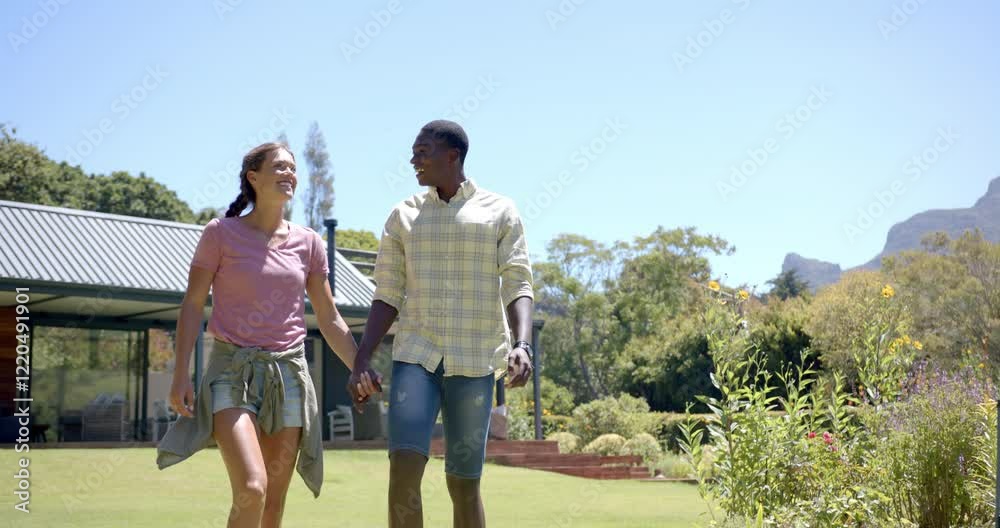 diverse couple holding hands and walking in garden, enjoying sunny day outdoors, copy space diverse couple holding hands and walking in garden, enjoying sunny day outdoors, copy space