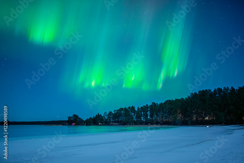 Northern lights dancing over frozen lake. Farnebofjarden national park in north of Sweden. photo