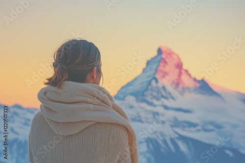 Woman in warm sweater admires a majestic sunset mountain view, feeling peaceful and serene. photo