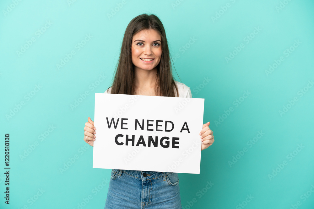 Young caucasian woman isolated on blue background holding a placard with text We Need a Change with happy expression Young caucasian woman isolated on blue background holding a placard with text We Need a Change with happy expression