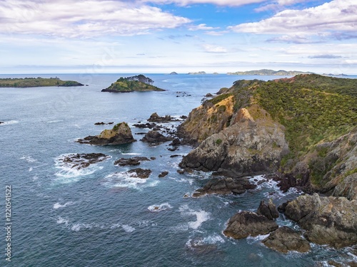 Coastal New Zealand scenery. Rocky shoreline with waves crashing against the rocks. Tranquil ocean views. MAHINEPUA PENINSULA, NORTHLAND, NZ photo