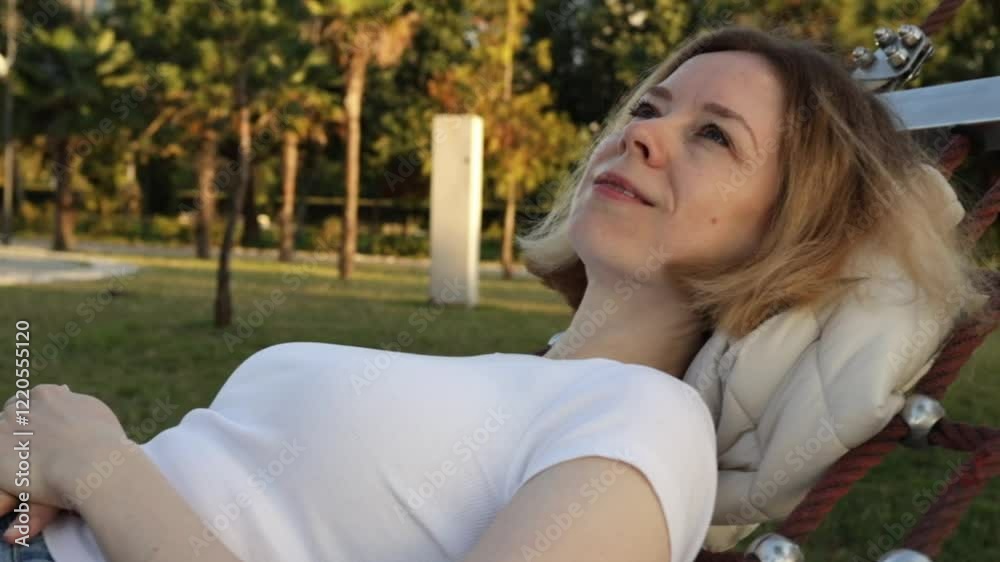 Relaxing Woman in Hammock at Sunset, travel and lifestyle with modern city buildings, urban relaxation and greenery combined. Relaxing Woman in Hammock at Sunset, travel and lifestyle with modern city buildings, urban relaxation and greenery combined.