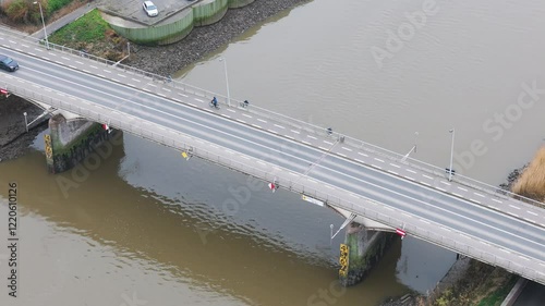 cars cyclist driving over bridge river below transportation modes area infrastructure forward aerial drone shot view perspective scenic overview  photo