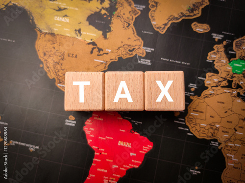 Top view wooden block with the word TAX on a world map background