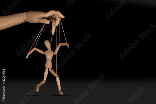 Wooden puppet doll, obeying master  hand pulling the strings of dancing marionette