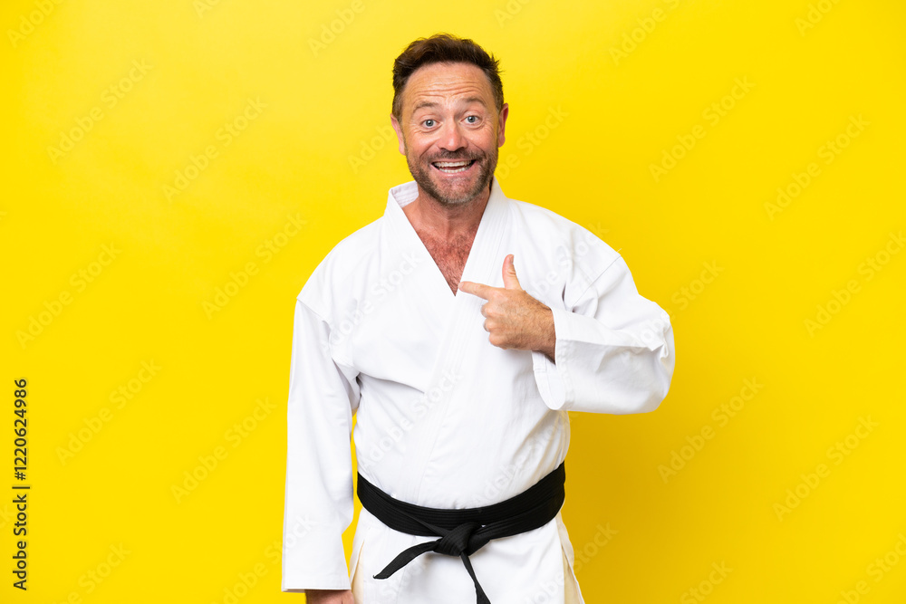 Middle age caucasian man doing karate isolated on yellow background with surprise facial expression Middle age caucasian man doing karate isolated on yellow background with surprise facial expression