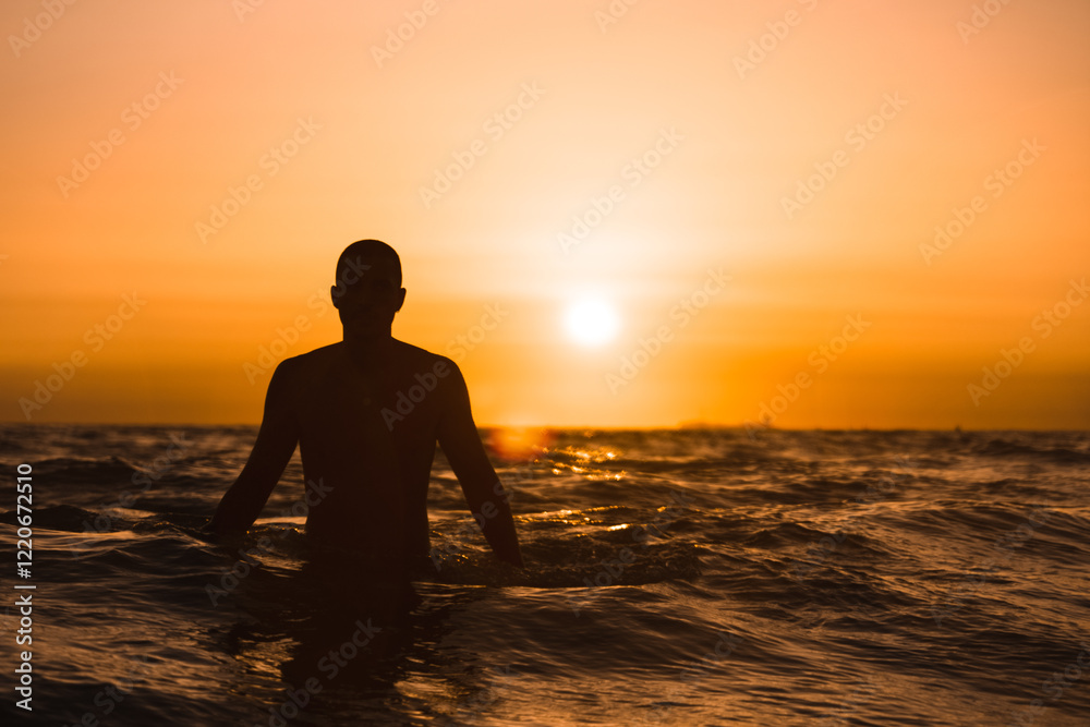 Fototapeta premium Silueta de hombre en el mar al atardecer