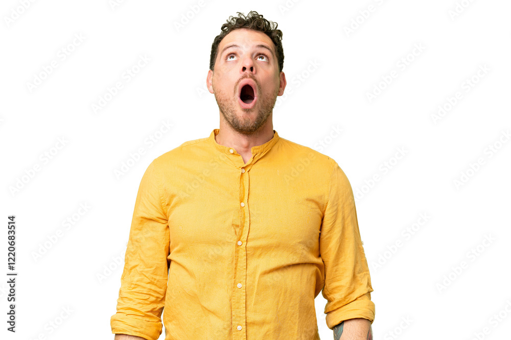 Brazilian man over isolated chroma key background looking up and with surprised expression Brazilian man over isolated chroma key background looking up and with surprised expression