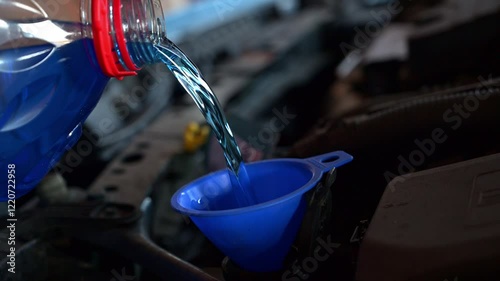 Nachfüllen von Scheibenfrostschutz in den Tank des Spritzwasserbehälters im Motorraum des Autos photo