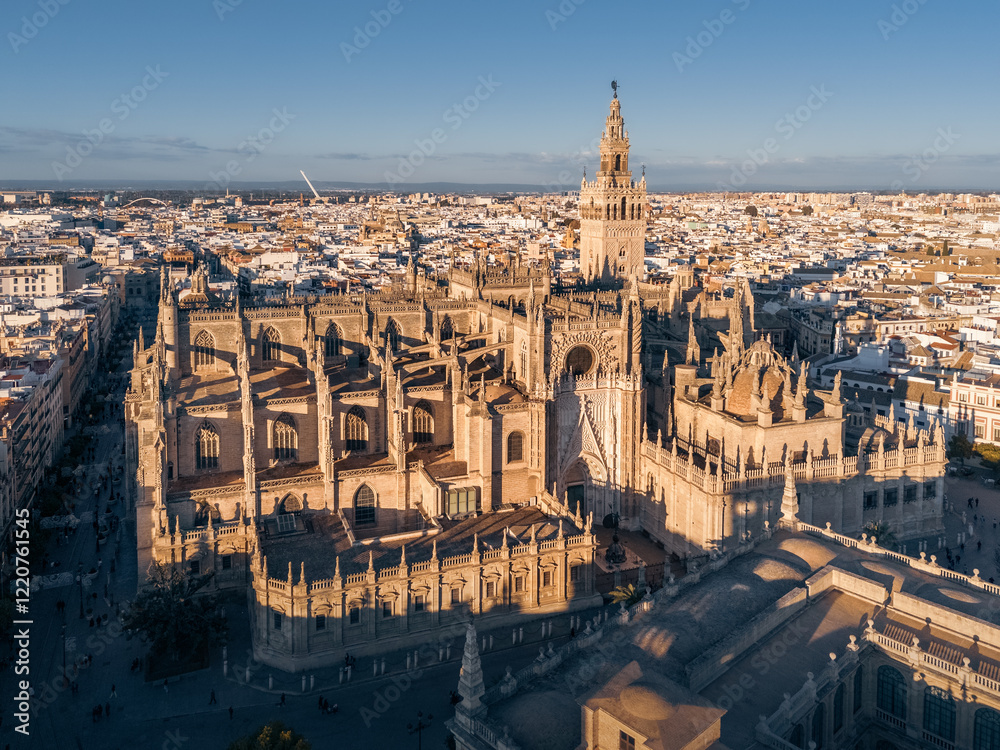 Fototapeta premium Aerial cityscape with Catedral de Sevilla and white buildings of old city at sunset, Seville, Spain