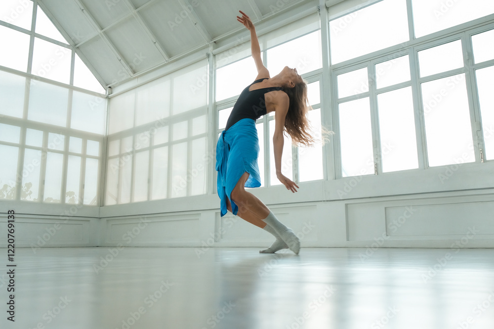 A medium view of a woman performing a sensual contemporary dance in a bright studio. Her movements are expressive, highlighting her confident and elegant style as she captivates the viewer. A medium view of a woman performing a sensual contemporary dance in a bright studio. Her movements are expressive, highlighting her confident and elegant style as she captivates the viewer.