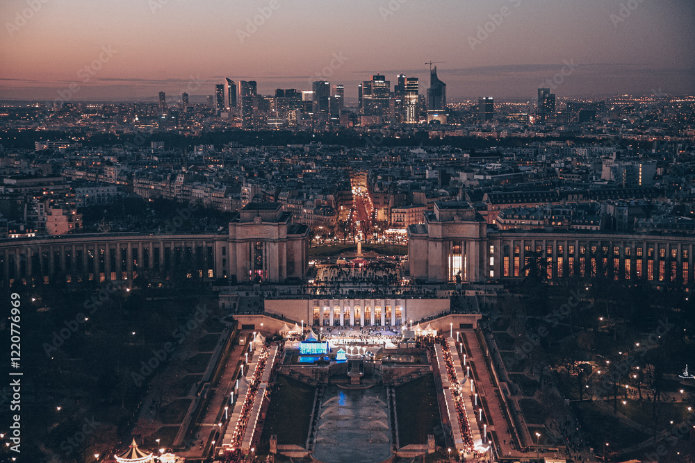 Fototapeta premium A Paris city with a large building in the center. The building is lit up at night. There are many cars on the street