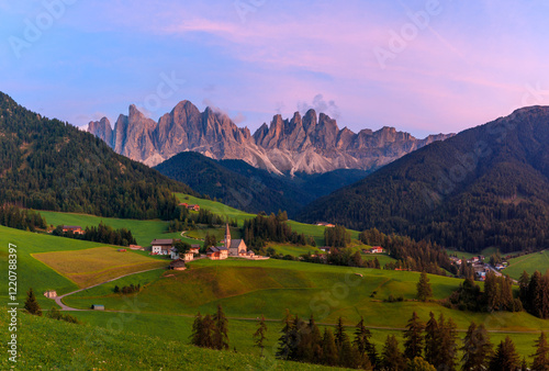 View above the Villnößtal Val di Funes with view on the Geislerspitzen Odlegruppa during sunrise warm light golden hour