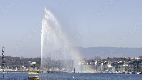 famous Jet d'Eau fountain in Geneva with boats in lake