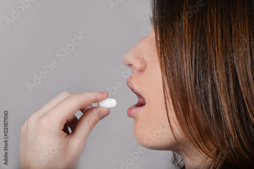 A person takes a white tablet orally. Drug use. Dietary supplements for health promotion. Traditional medicine. Chemical action on the body. Vitamin intake