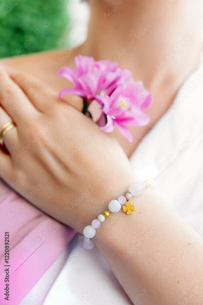 Fototapeta premium Woman's hand with wrist bracelet, bracelet with natural stones, handmade jewelry, gift idea for a woman, artistic gel nails, smooth hand skin.