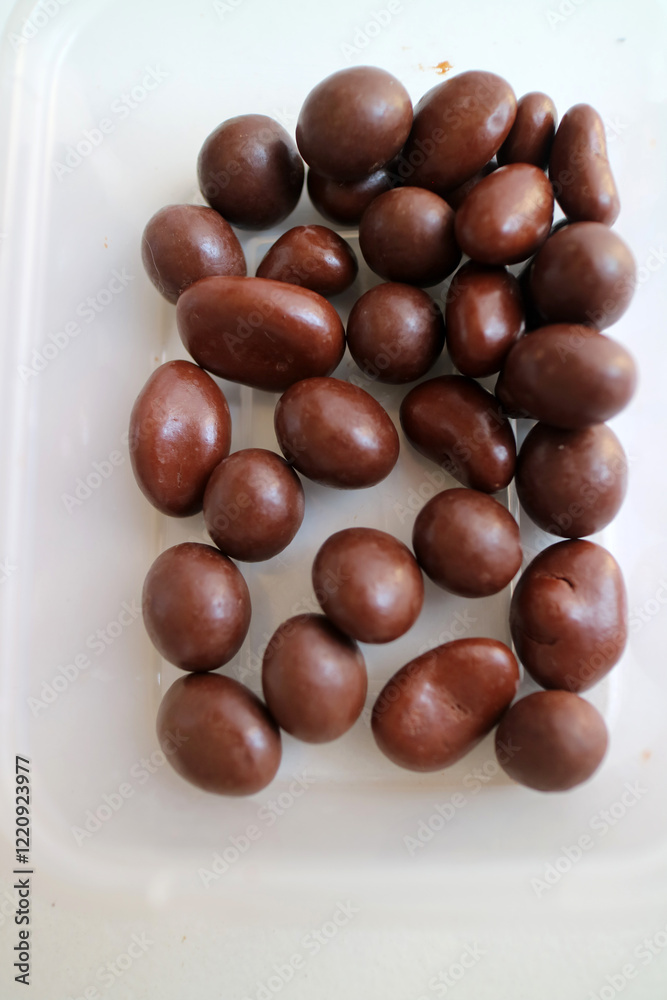 Photo of some dark brown chocolate granules, in plastic container Photo of some dark brown chocolate granules, in plastic container