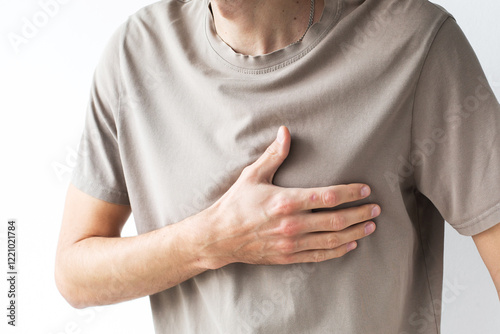 Man holding his chest with one hand, expressing pain or discomfort, possibly indicating heart-related issues such as chest pain, heart attack, cardiovascular problems, white background