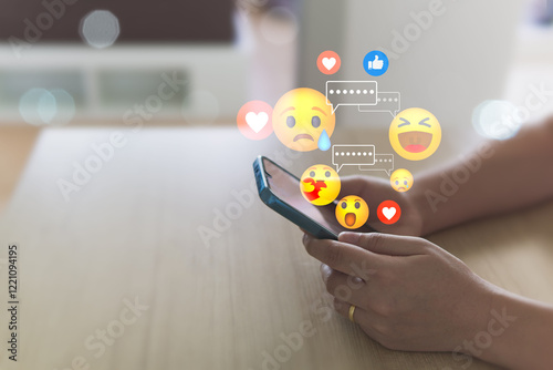 Social media concepts include exchange of ideas, socializing through the internet, technology, and social networking. A woman uses a mobile phone to send emojis to her friends while relaxing at home.