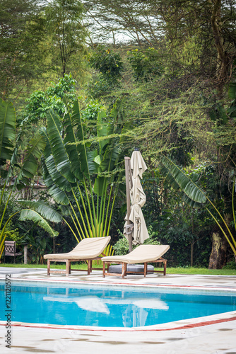 Enjoying the beautiful weather on relaxing chair under a parasol along the pool