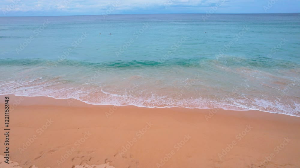 Gentle waves washing sandy beach on cloudy day Gentle waves washing sandy beach on cloudy day